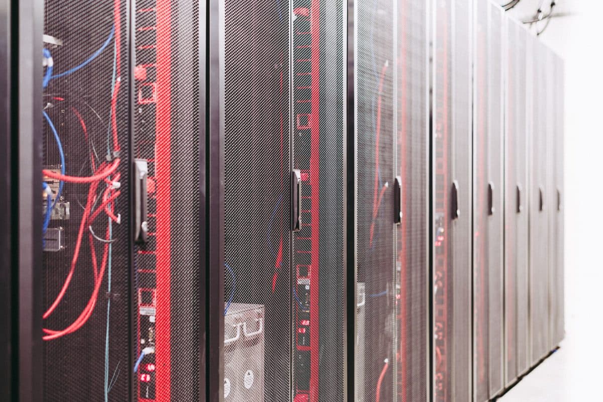 Rows of illuminated server racks in a data center, representing the infrastructure layer that AI agent standards run on