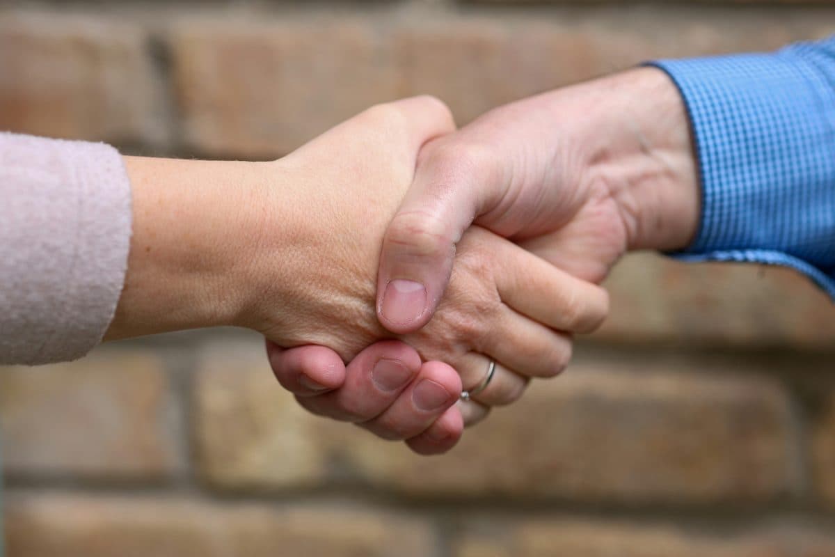 Two people shaking hands, representing the cross-border partnerships behind China's open source AI expansion into new markets