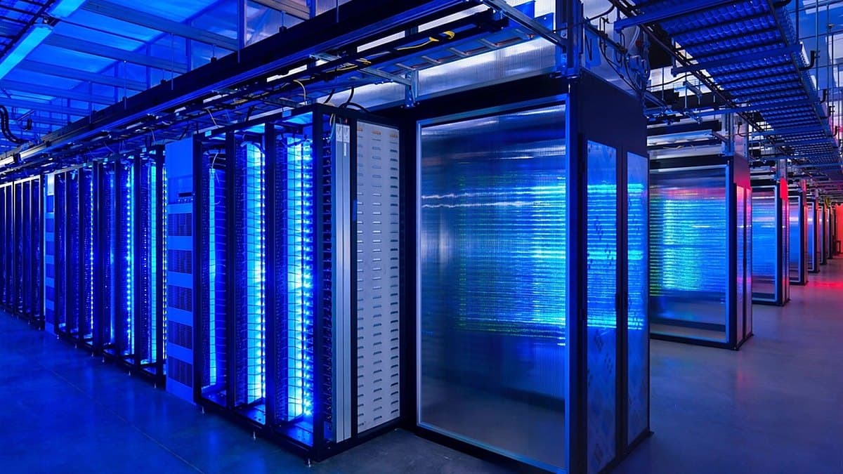 Rows of illuminated server racks in a data centre, the compute whose electricity demand the claims turn on
